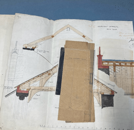 A stack of creased paper in layers showing a cream coloured plan with architectural details and measures with a smaller stack of folded tracing paper pages.