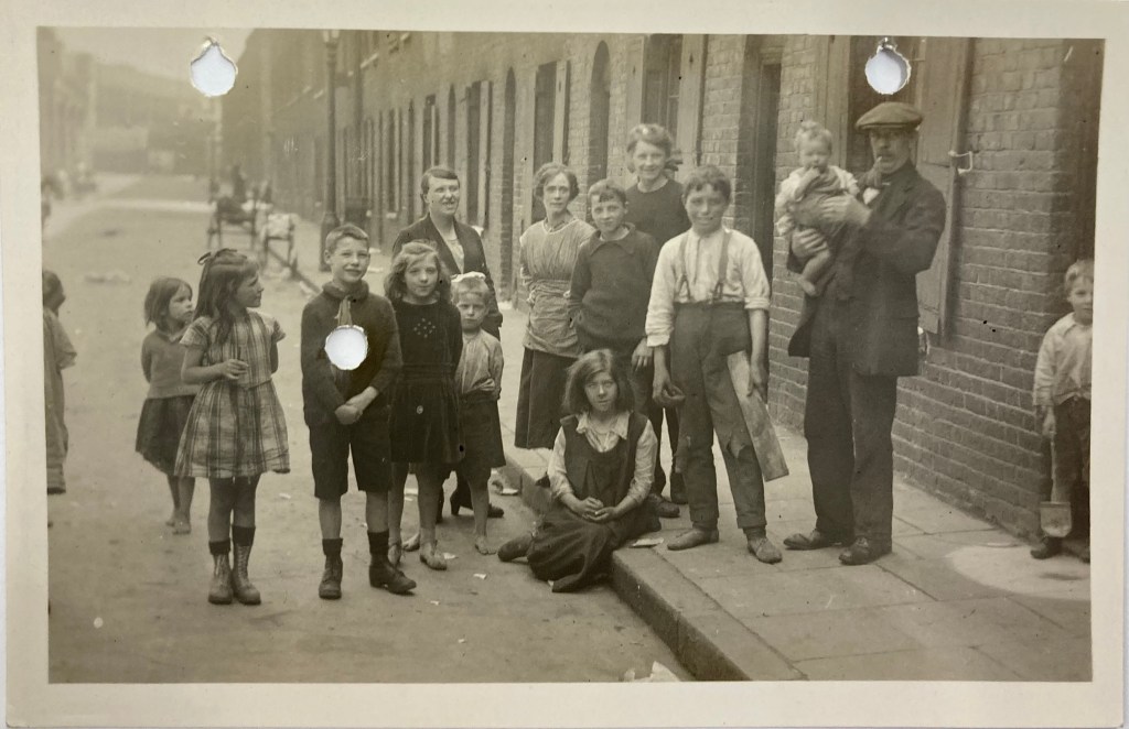 A group of people standing in the street with several children