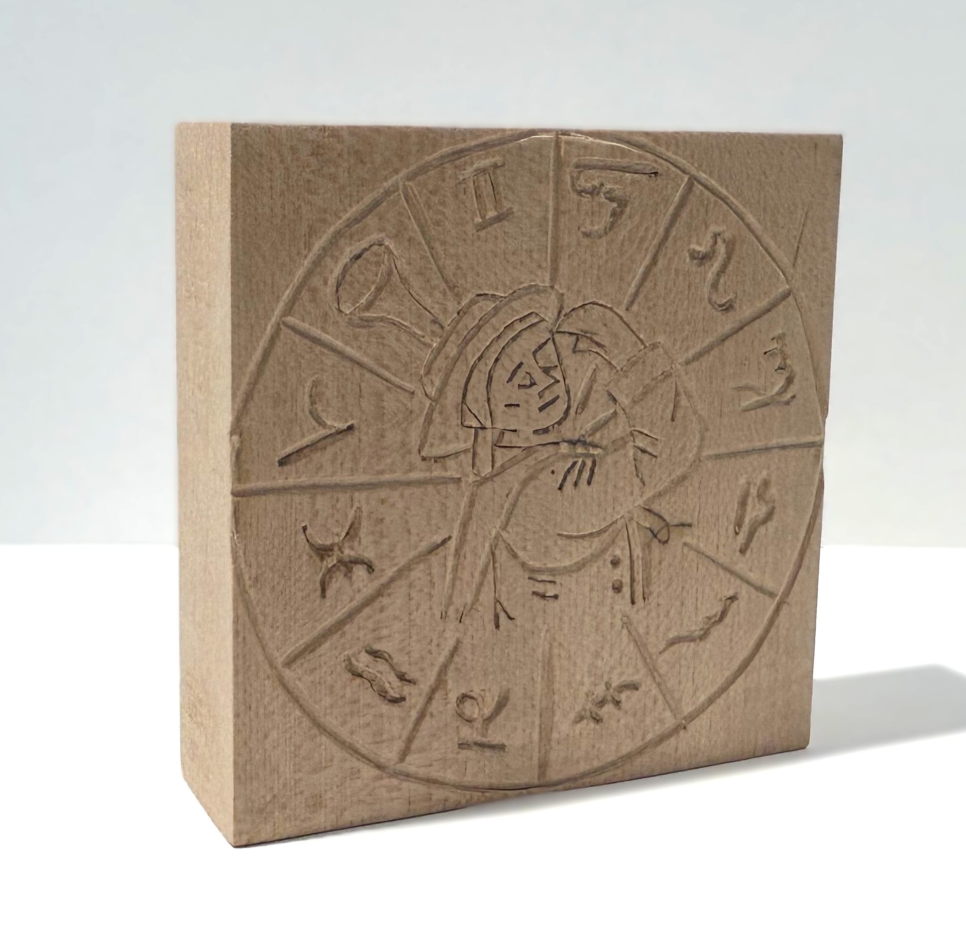 Finished wooden block with shepherd and zodiac signs carved into it